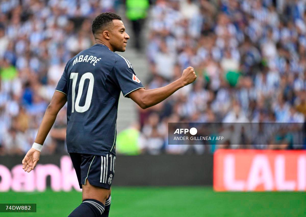 Real Madrid's French forward #10 Kylian Mbappe celebrates scoring his team's first goal during the Spanish league football match between Real Sociedad and Real Madrid CF at Anoeta Stadium in San Sebastian on September 13, 2025. - AFP