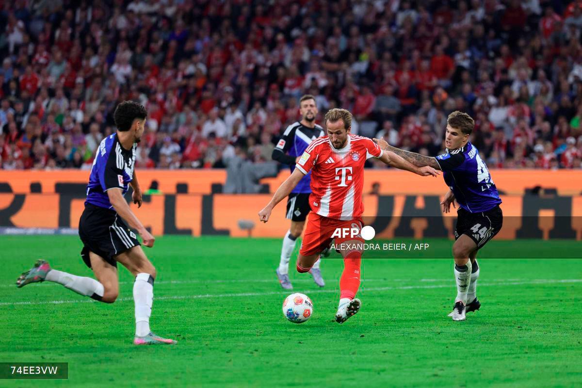 Bayern Munich's English forward #09 Harry Kane (C) kicks to score the 5-0 goal during the German first division Bundesliga football match between FC Bayern Munich and HSV Hamburg in Munich, southern Germany, on September 13, 2025. - AFP