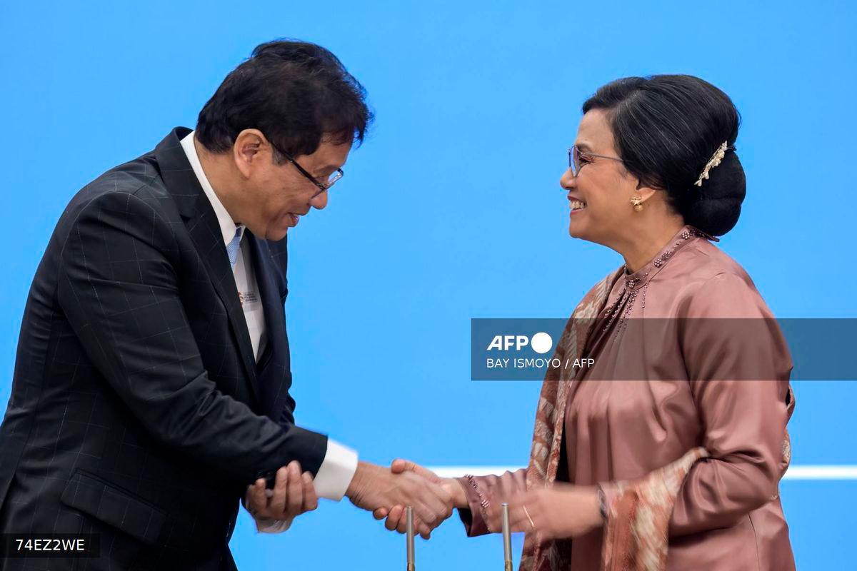 (FILES) Indonesia’s newly appointed Finance Minister Purbaya Yudhi Sadewa (L) and his predecessor Sri Mulyani Indrawati (R) shake hands after signing documents during the handover ceremony at the Ministry of Finance in Jakarta on September 9, 2025. In removing Indonesia’s finance minister and U-turning on protester demands, the leader of Southeast Asia’s biggest economy is scrambling to restore public trust while seizing a chance to install loyalists after deadly riots last month, experts say. (Photo by BAY ISMOYO / AFP)