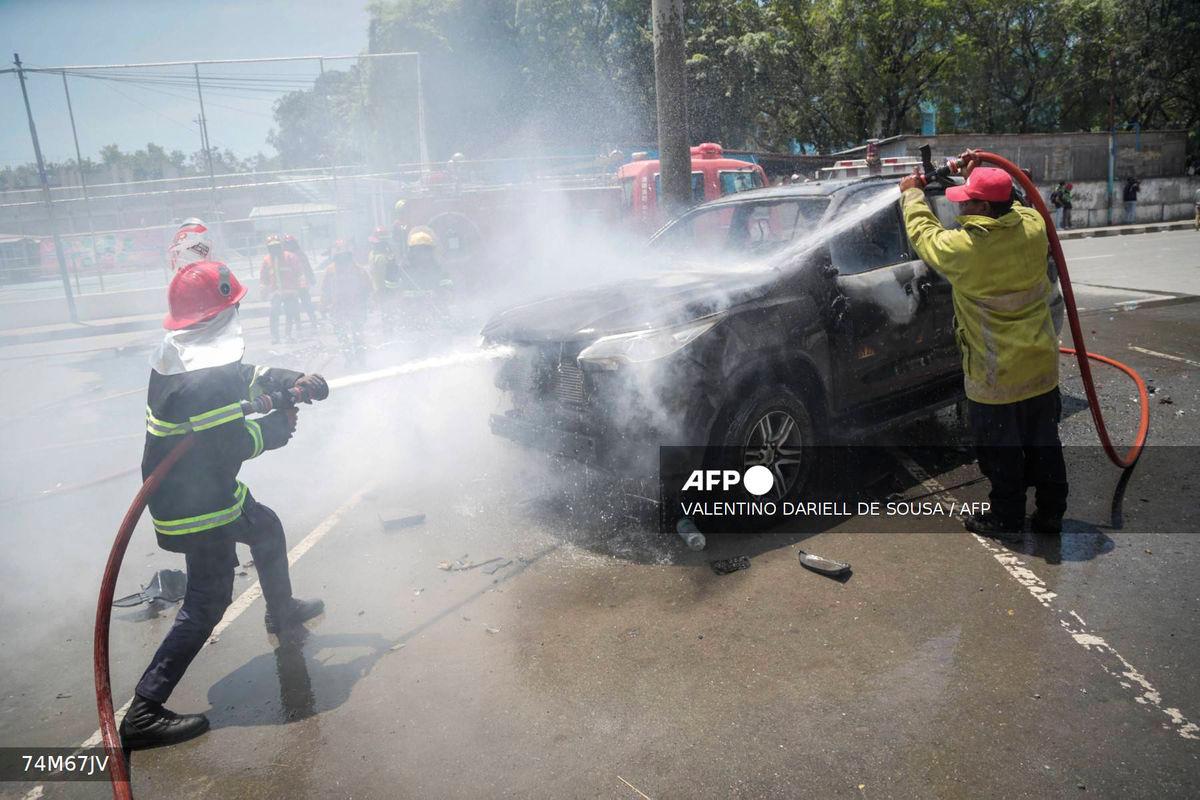 Firefighters extinguish a government vehicle set alight by university students protesting the parliament’s plan to buy 65 SUVs for lawmakers in Dili, East Timor, on September 16, 2025. (Photo by VALENTINO DARIELL DE SOUSA / AFP)
