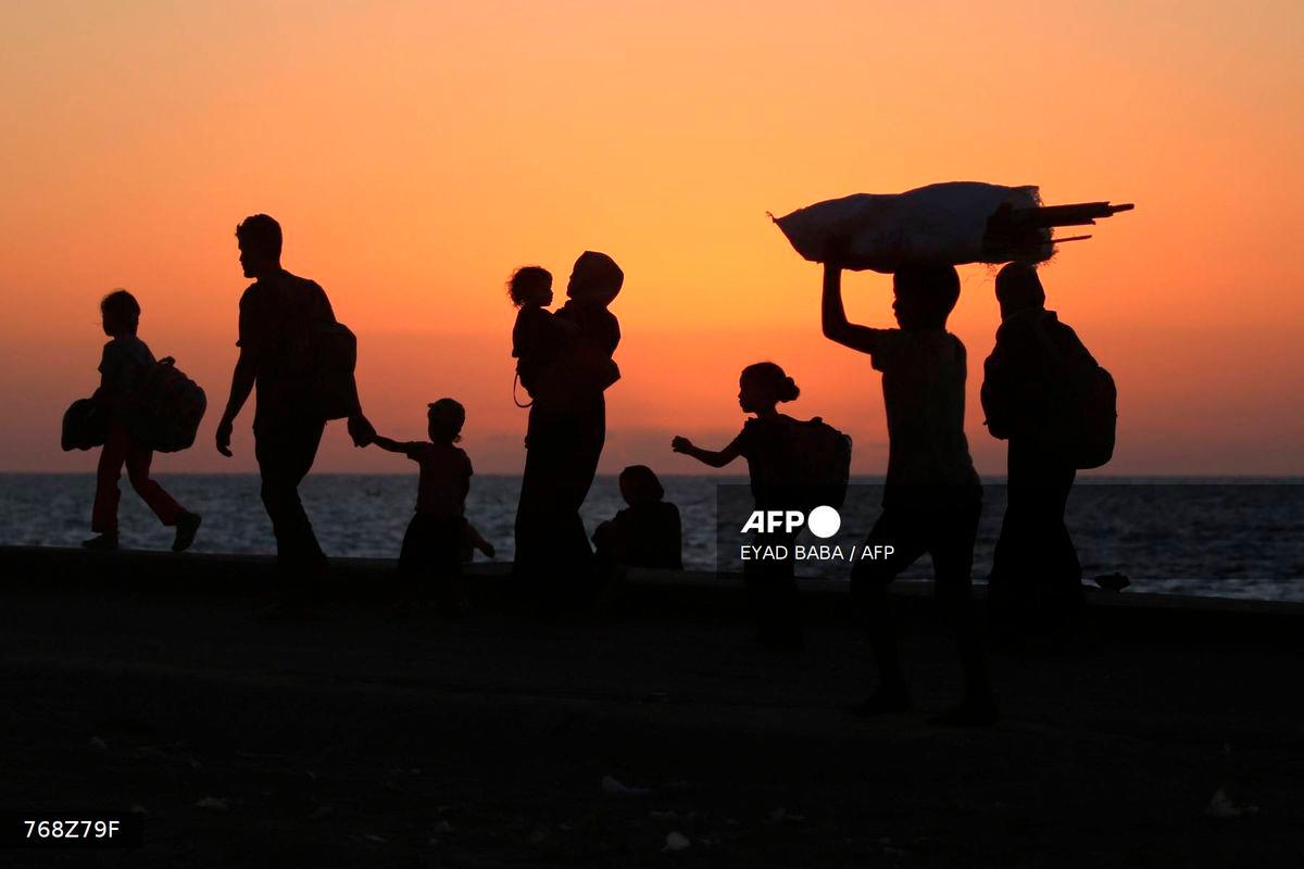 Displaced Palestinians move with their belongings southwards on a road in the Nuseirat refugee camp area in the central Gaza Strip on September 20, 2025, as Israel presses its ground offensive to capture Gaza City. - AFP