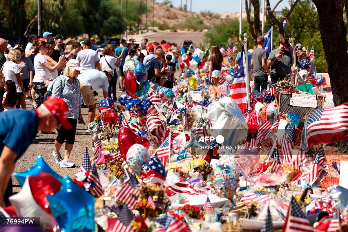 People gather at a makeshift memorial for right-wing activist and Turning Point USA founder Charlie Kirk outside of their headquarters in Phoenix, Arizona, on September 20, 2025. (Photo by CHARLY TRIBALLEAU / AFP)