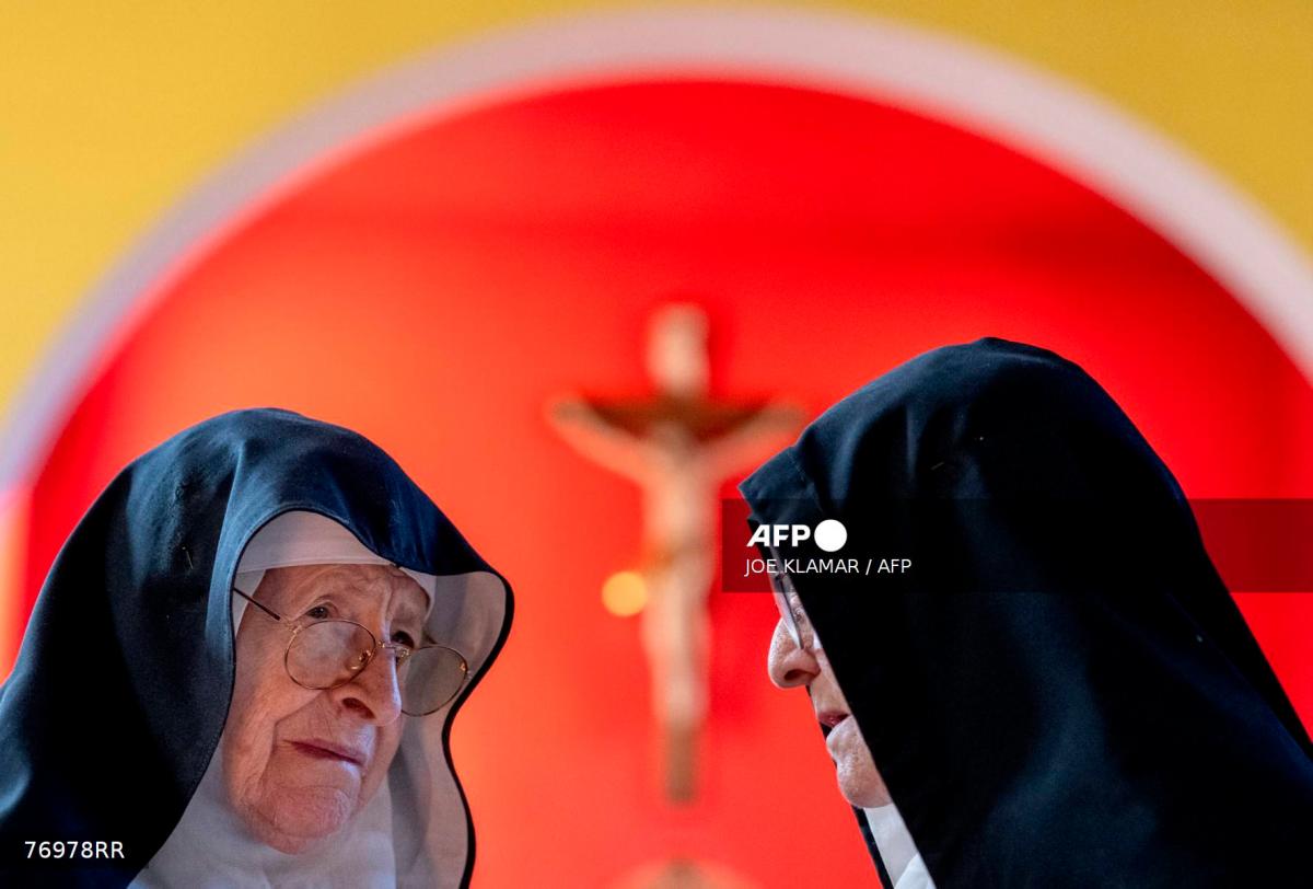 Sisters Rita (L), 81, and Regina, 86, react to a dozen of supporters and former students, at the convent chapel of the Goldenstein castle, in the municipality of Elsbethen, south of Salzburg city, Austria on September 20, 2025. (Photo by Joe Klamar / AFP)
