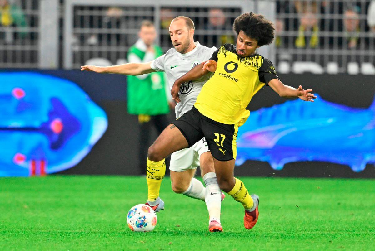 Wolfsburg’s midfielder Christian Eriksen (L) and Dortmund’s forward Karim Adeyemi vie for the ball during the German first division Bundesliga football match between Borussia Dortmund and VfL Wolfsburg in Dortmund on September 21, 2025. - AFP