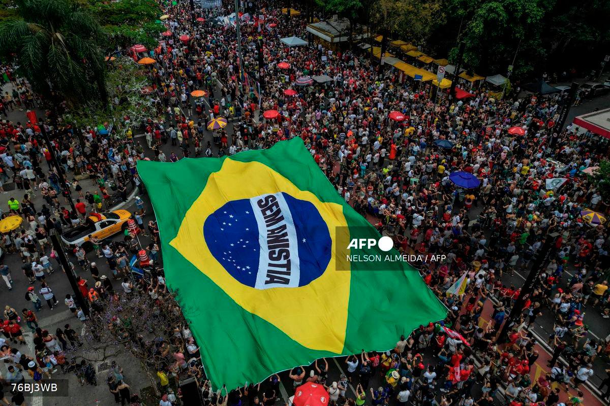 This aerial view shows people carrying a huge Brazilian flag reading No amnesty during a protest against a constitutional amendment known as the Shielding Project, which requires Congress to authorize any criminal charges against deputies and senators through a secret vote, in Sao Paulo, Brazil, on September 21, 2025.- AFP