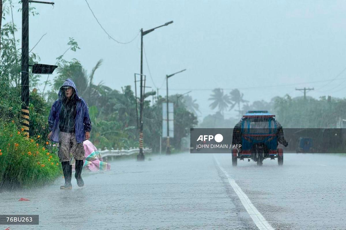 A man walks along a road amid heavy rain due to weather patterns from Super Typhoon Ragasa in Lal-lo town, Cagayan province on September 22, 2025. - AFP