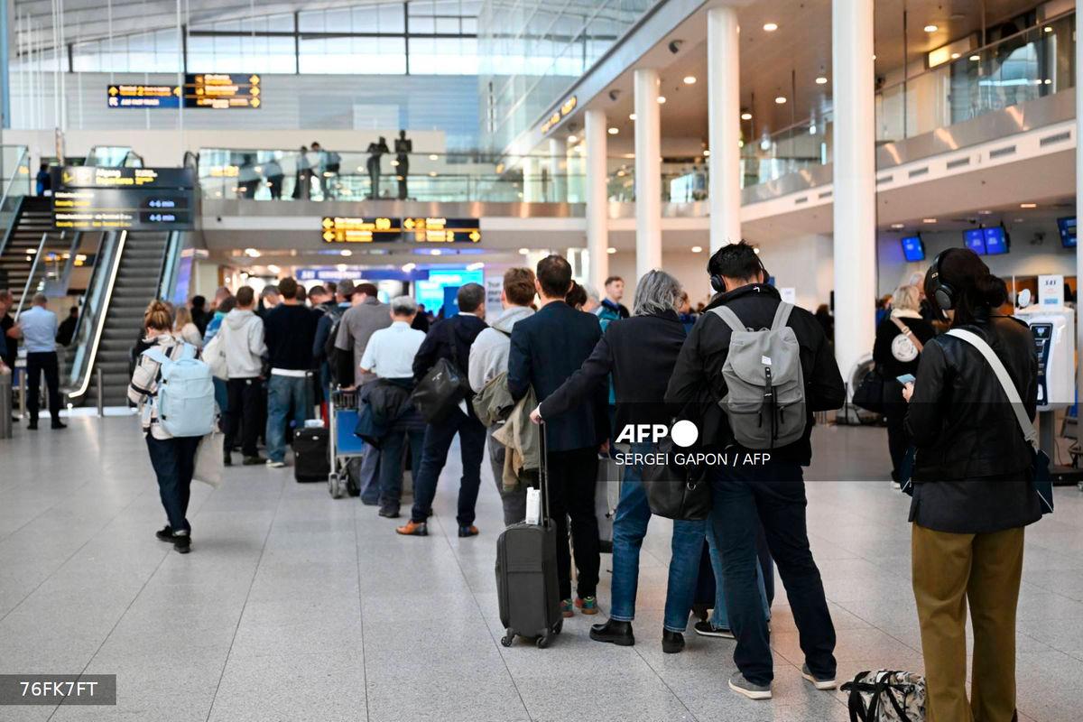 Passengers stand in a queue to get new tickets at the service point of the Copenhagen Airport in Copenhagen, Denmark, on September 23, 2025. (Photo by Sergei GAPON / AFP)