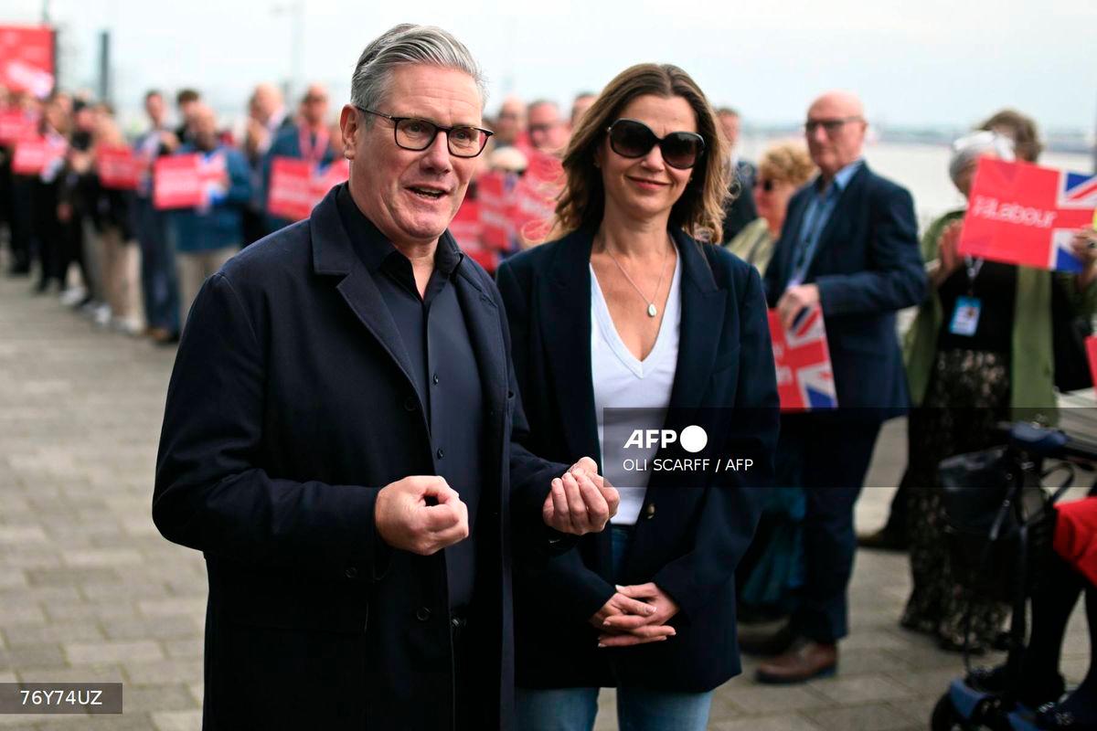 Britain's Prime Minister Keir Starmer speaks to members of the media as he arrives with his wife Victoria ahead of the annual Labour Party conference in Liverpool, north-west England, on September 27, 2025. - AFP