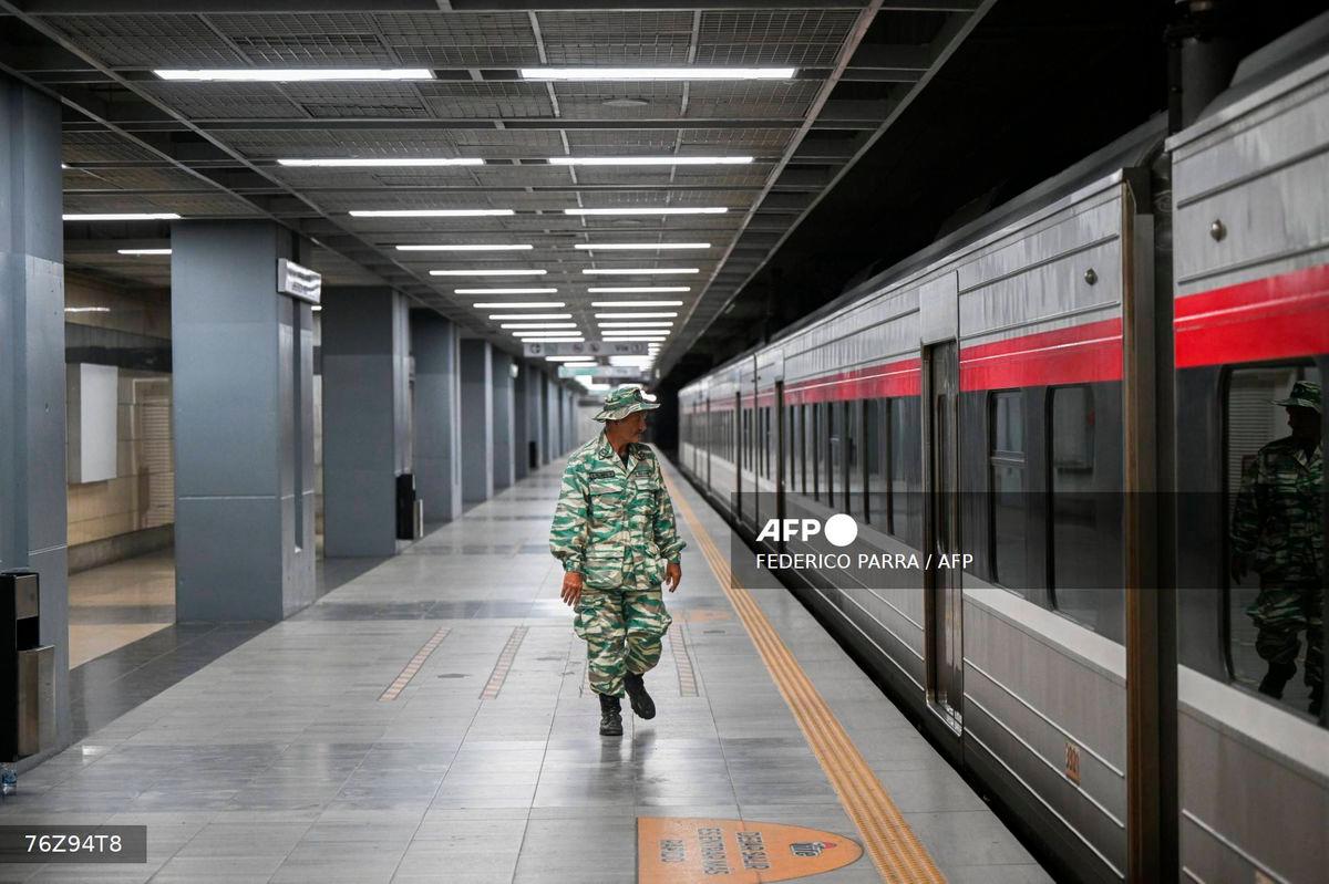 A member of the Bolivarian militia inspects an evacuated train station during a risk reduction drill on natural disasters or armed conflict in Caracas on September 27, 2025. (Photo by Federico PARRA / AFP)