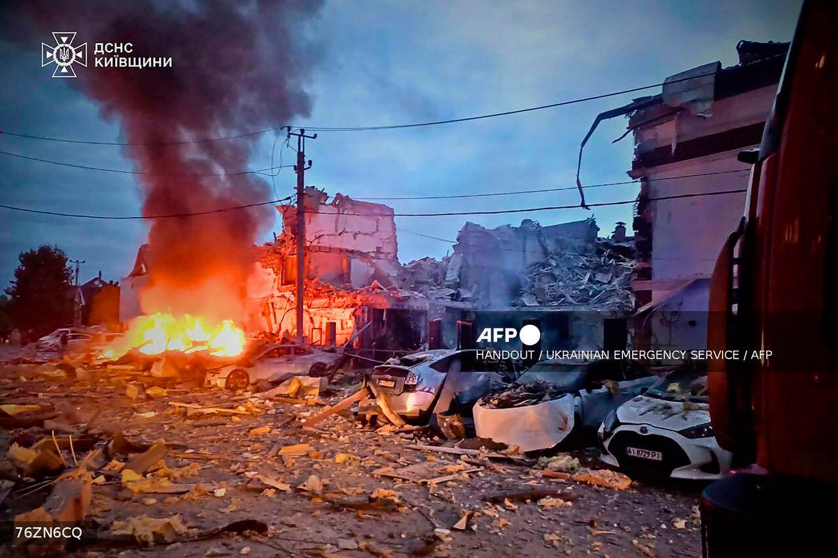 Destroyed buildings and burning cars at the site of an air attack at an undisclosed location in the Kyiv region, amid the Russian invasion of Ukraine. (Photo by Handout / UKRAINIAN EMERGENCY SERVICE / AFP)