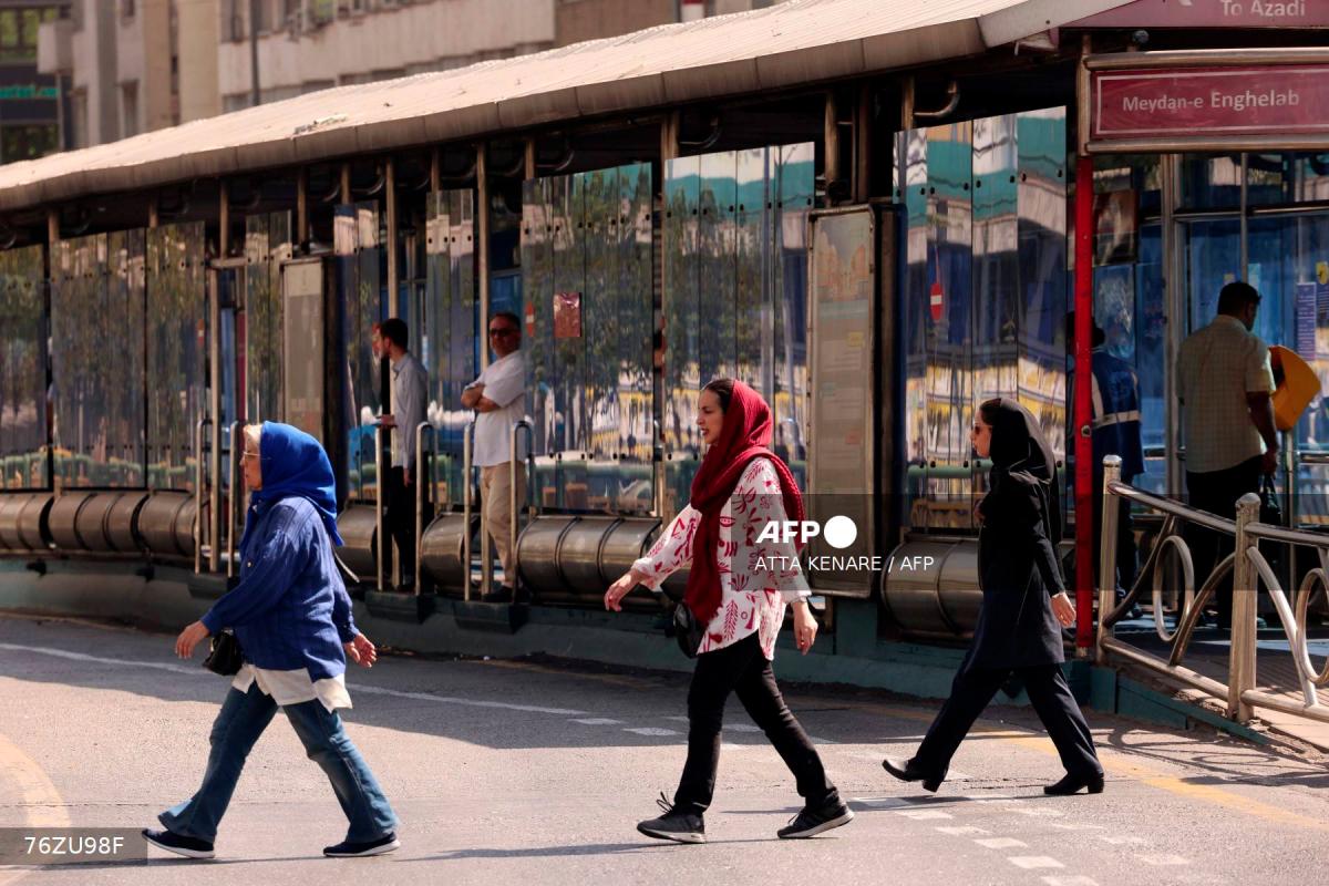 Iranian women walk in front of a public transportation station in Tehran on September 28, 2025. - AFPPIX