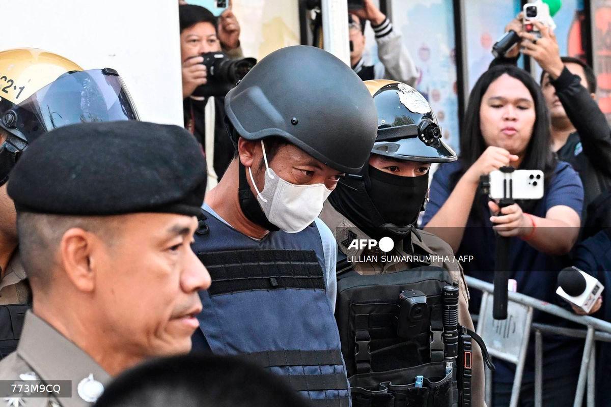 (FILES) Thai national Ekkalak Paenoi (C), a suspect in the alleged killing of former lawmaker of the dissolved Cambodia National Rescue Party (CNRP) Lim Kimya, is escorted into a police van to transport him to the Criminal Court from Chana Songkram Police Station in Bangkok on January 13, 2025. A Thai gunman was sentenced to life in prison on October 3, 2025 for the murder of Cambodian opposition politician Lim Kimya in Bangkok, the judge said. - AFP