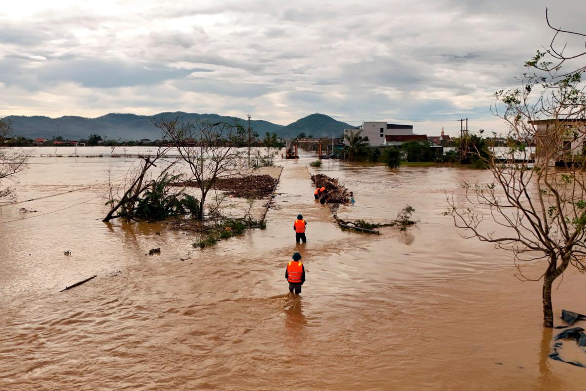An aerial photo shows rescue workers walking through flood waters after typhoon Bualoi passed over Lam Thanh commune in Nghe An province on September 30, 2025. - Phan Duy / AFP