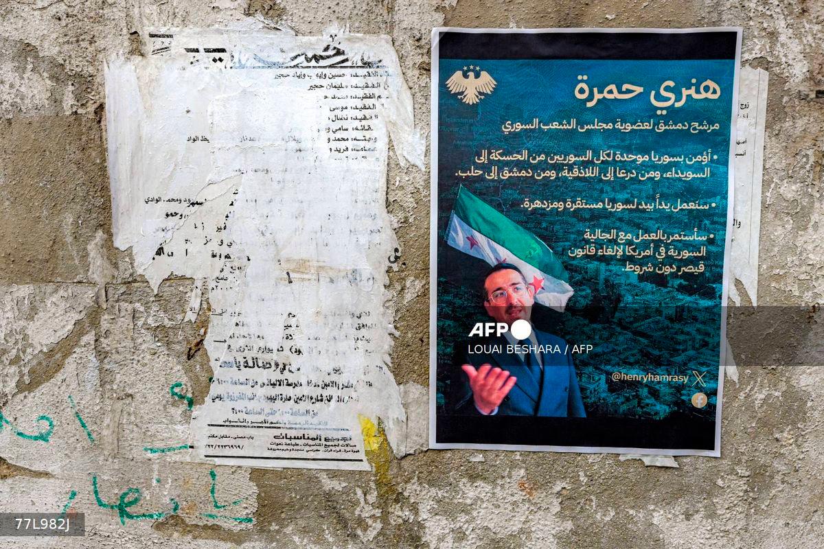 Election posters of Henry Hamra, a Syrian-American parliamentary candidate who is the son of the country's last rabbi and who if elected will be the first Jewish representative in the Syrian parliament since the late 1940s, are displayed on a wall along an alley in the Jewish quarter of the old city of Damascus on October 3, 2025, ahead of the upcoming vote on October 5. - AFP