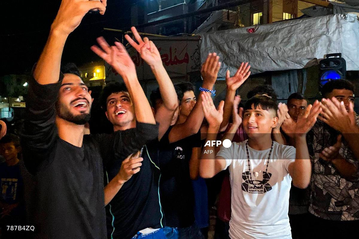 Palestinians celebrate in Khan Yunis on October 9, 2025, following news of a new Gaza ceasefire deal. US President Donald Trump announced that Israel and Hamas have agreed to the first phase of a ceasefire in Gaza, after days of indirect talks in Egypt. (Photo by AFP)