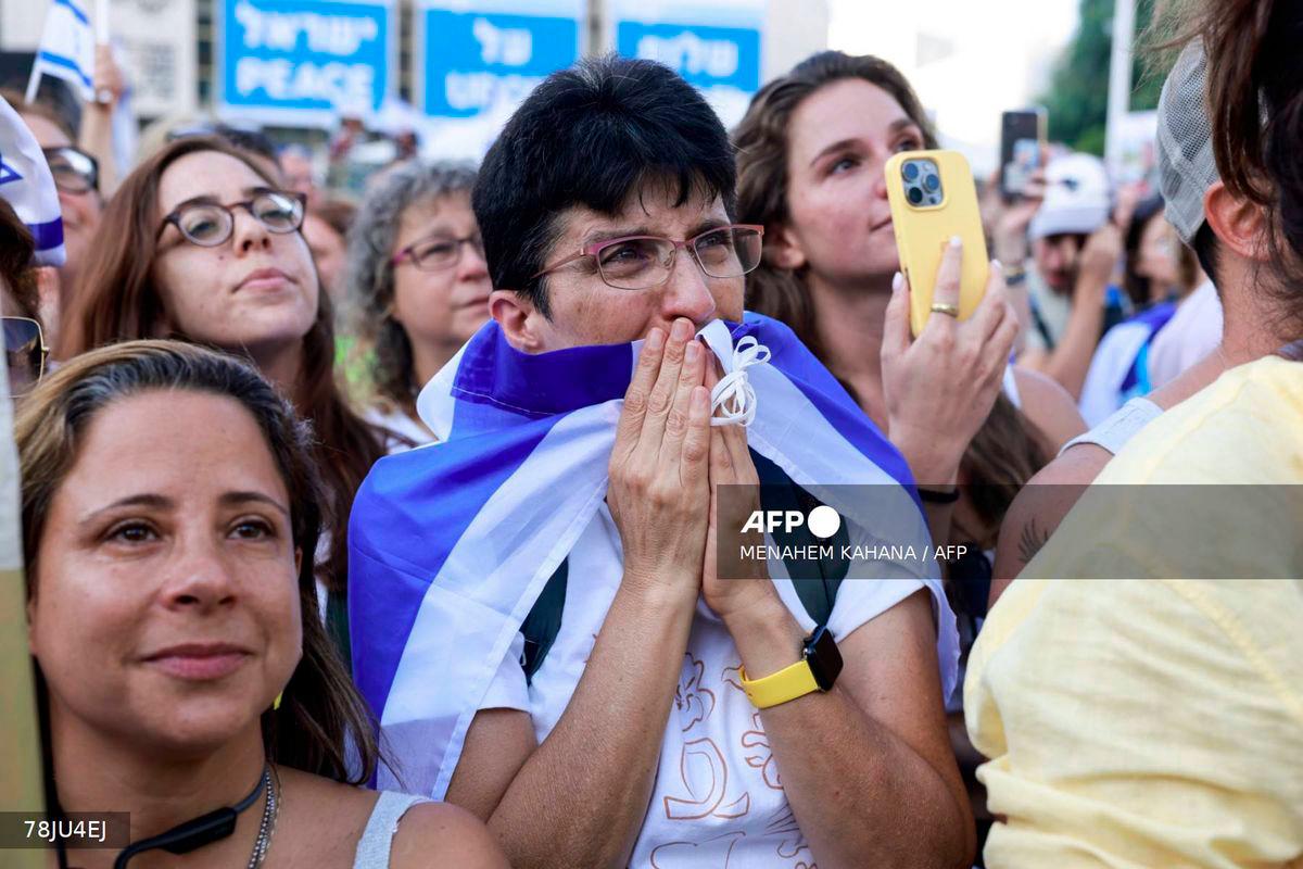 A woman reacts as people celebrate at Hostage Square in Tel Aviv as news came out that Hamas has already handed over seven surviving hostages to the Red Cross on October 13, 2025. - AFP
