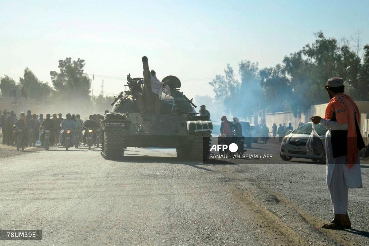 Taliban security personnel on a Soviet-era tank are followed by motorcyclists as they ride towards the border, during ongoing clashes between Taliban security personnel and Pakistani border forces, in the Spin Boldak district of Kandahar Province on October 15, 2025. - Sanaullah SEIAM / AFP