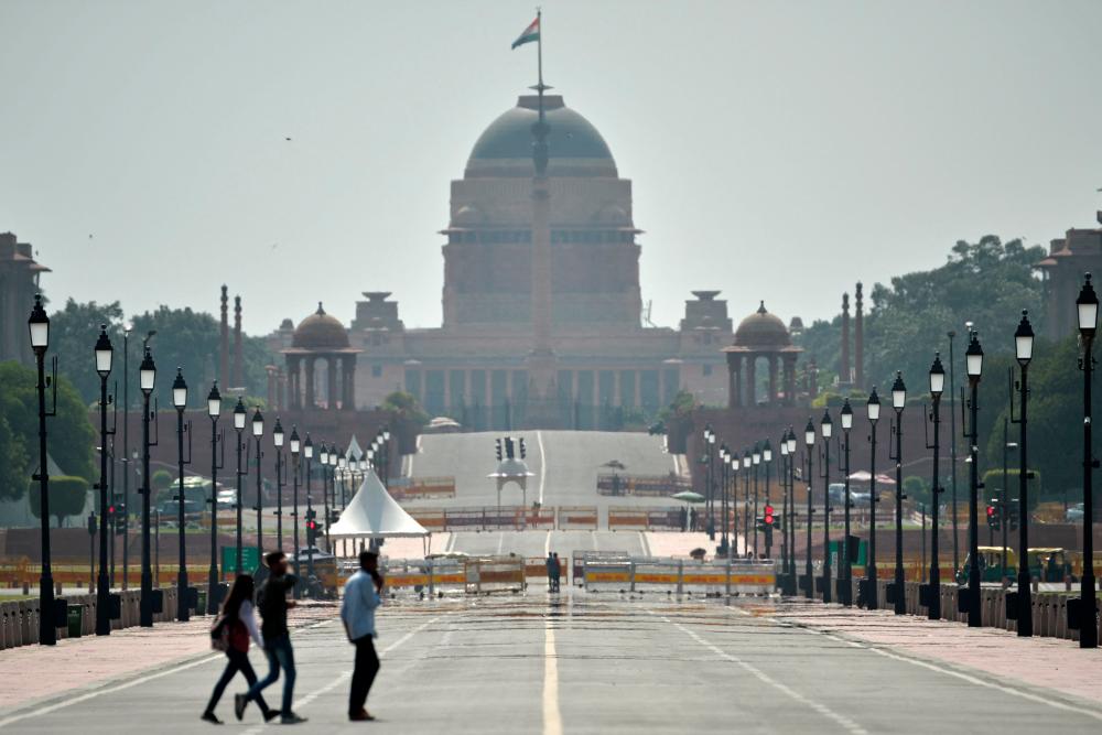 Commuters walk through a mirage on a hot summer day in front of India's presidential palace Rashtrapati Bhavan in New Delhi on May 21, 2023. - AFPPIX