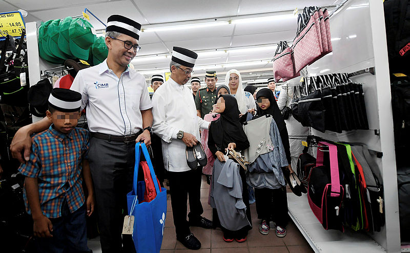 The Yang di-Pertuan Agong Al-Sultan Abdullah Ri’ayatuddin Al-Mustafa Billah Shah, speaks to a child from the Sultanah Hajjah Kalsom Children’s Home, as CIMB Group chief executive officer Tengku Datuk Seri Zafrul Aziz (2nd L) looks on, on May 30, 2019. — Bernama