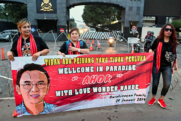 Supporters of former Jakarta governor Basuki Tjahaja Purnama, popularly known as Ahok, display a banner in front of the police headquarters in Depok, south of Jakarta in West Java province. — AFP