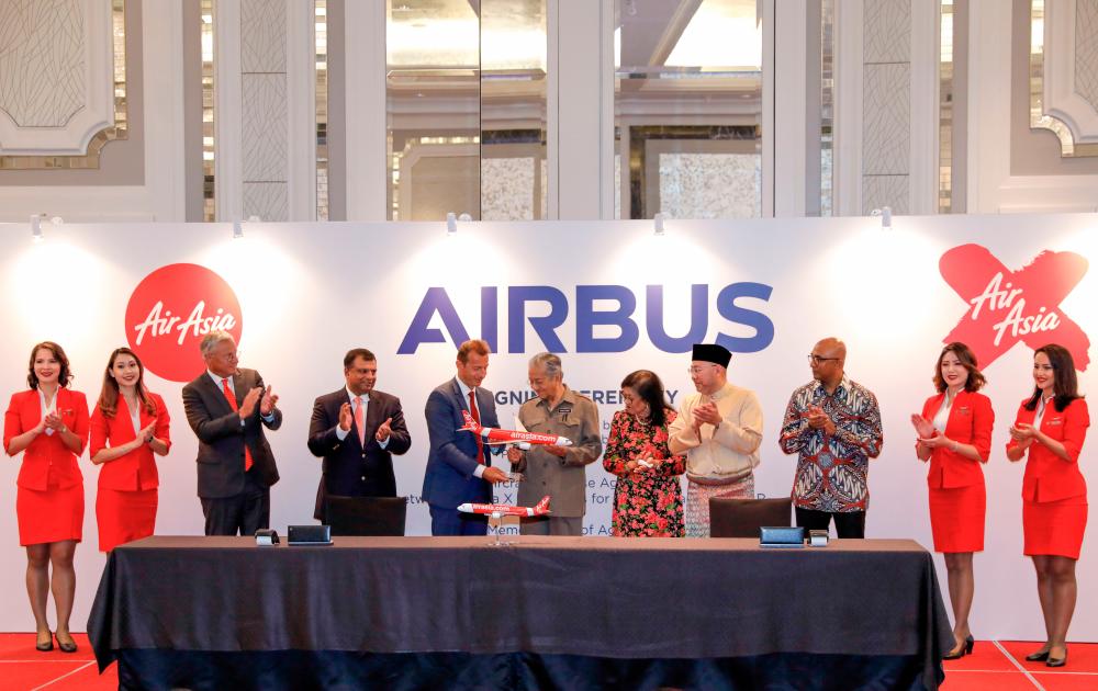 From left: Airbus chief commercial officer Christian Scherer, Fernandes, Faury, Mahathir, Rafidah, Kamarudin, AirAsia Group president (airlines) Bo Lingam flanked by cabin crew.