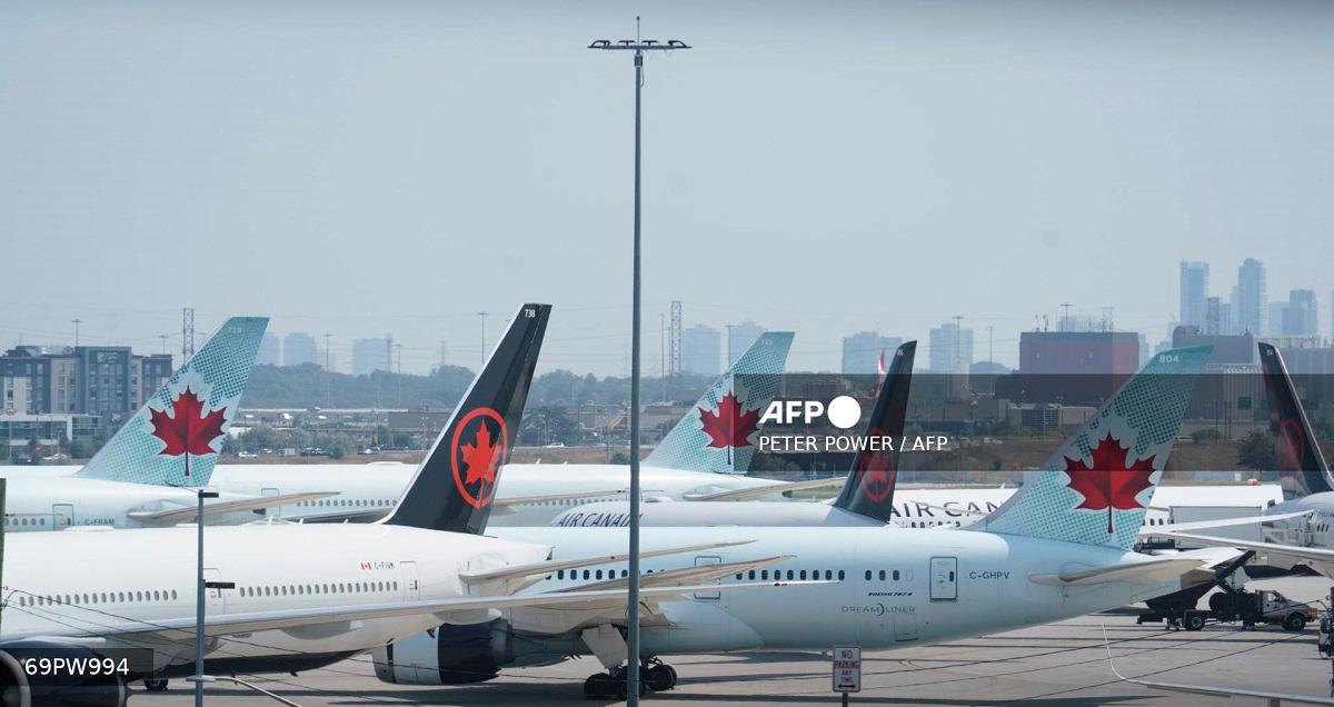 Air Canada airplanes stand on the tarmac at Pearson International Airport in Toronto on August 16, 2025. Air Canada cancelled hundreds of flights Saturday as it began shutting down operations in response to a strike by flight attendants -- triggering summer travel chaos for its 130,000 daily passengers. Canada's largest airline, which flies directly to 180 cities worldwide, urged customers not to go to the airport if they have a ticket for Air Canada or its lower-cost subsidiary Air Canada Rouge. - Peter POWER / AFP