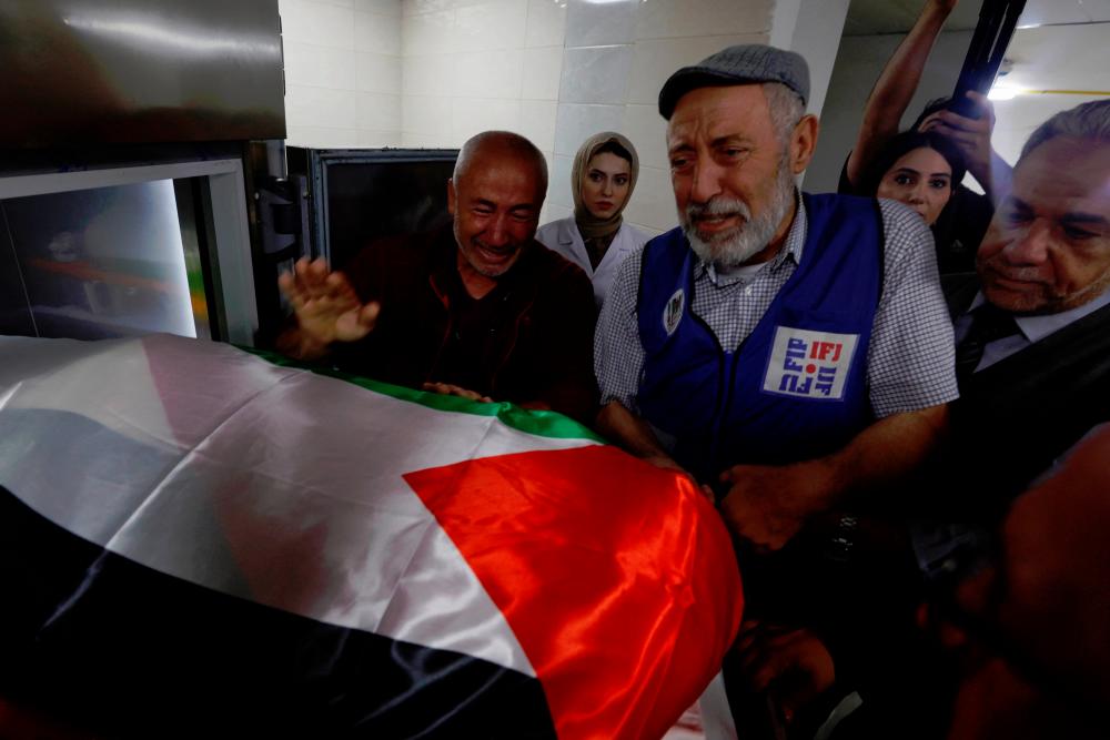 Mourners react next to the body of Al Jazeera reporter Shireen Abu Akleh, who was killed by Israeli army gunfire during an Israeli raid, according to the Qatar-based news channel, in Jenin in the Israeli-occupied West Bank. - REUTERSpix