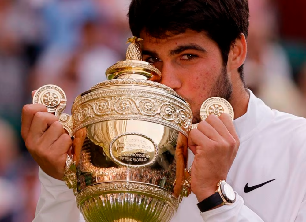 Tennis - Wimbledon - All England Lawn Tennis and Croquet Club, London, Britain - July 16, 2023 Spain’s Carlos Alcaraz celebrates with the trophy after winning his final match against Serbia’s Novak Djokovic. REUTERSPIX