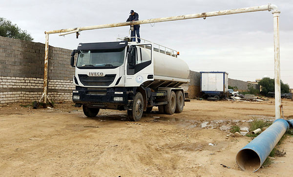 Al-Sid Chanta, a trucker who collects water supplied from a reservoir to deliver to residents’ homes, fills his tank with water at the Zentan water pumping station, in the city of Zintan, 170 km southwest of Tripoli. — AFP