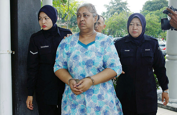 M. A. S. Ambika, the accused in the case, is accompanied by policewomen. The picture was taken on Feb 10, 2018. — BBXpress