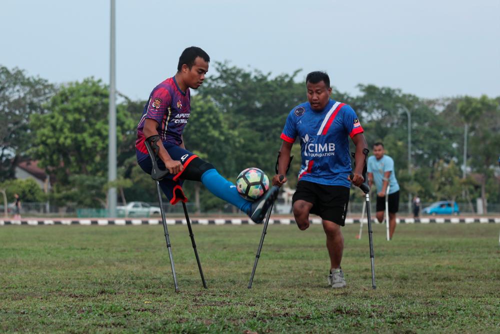 $!2. Haqimie (left) during a friendly match with the Melaka Amputee Football Team in Kelebang, Melaka.