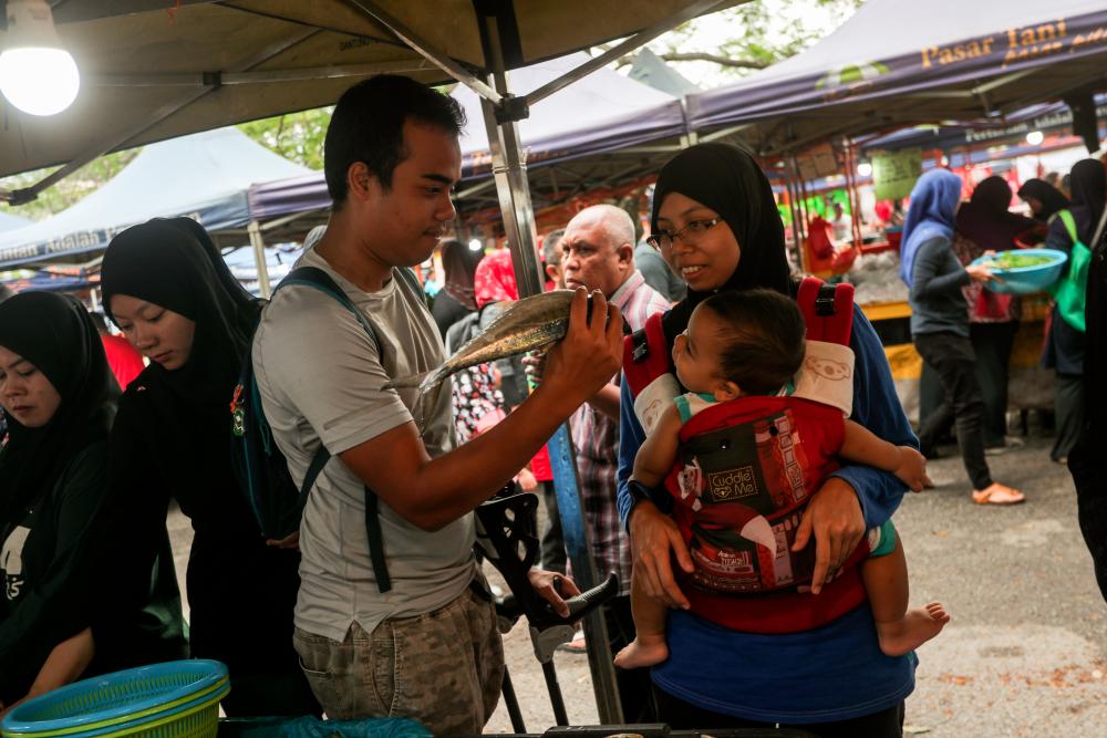 $!8. Haqimie and his wife enjoying the farmer's market in Shah Alam with their baby.