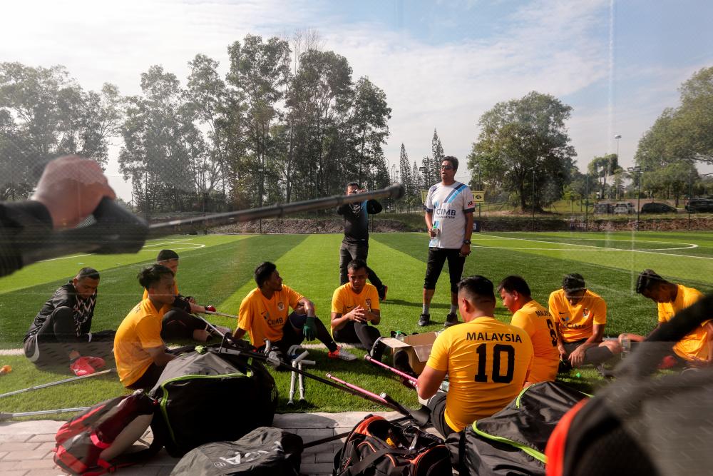 $!9. Assistant coach Edwin Roch (center) briefs the Malaysia amputee football team before their friendly match with The Ohana FC at Shah Alam.