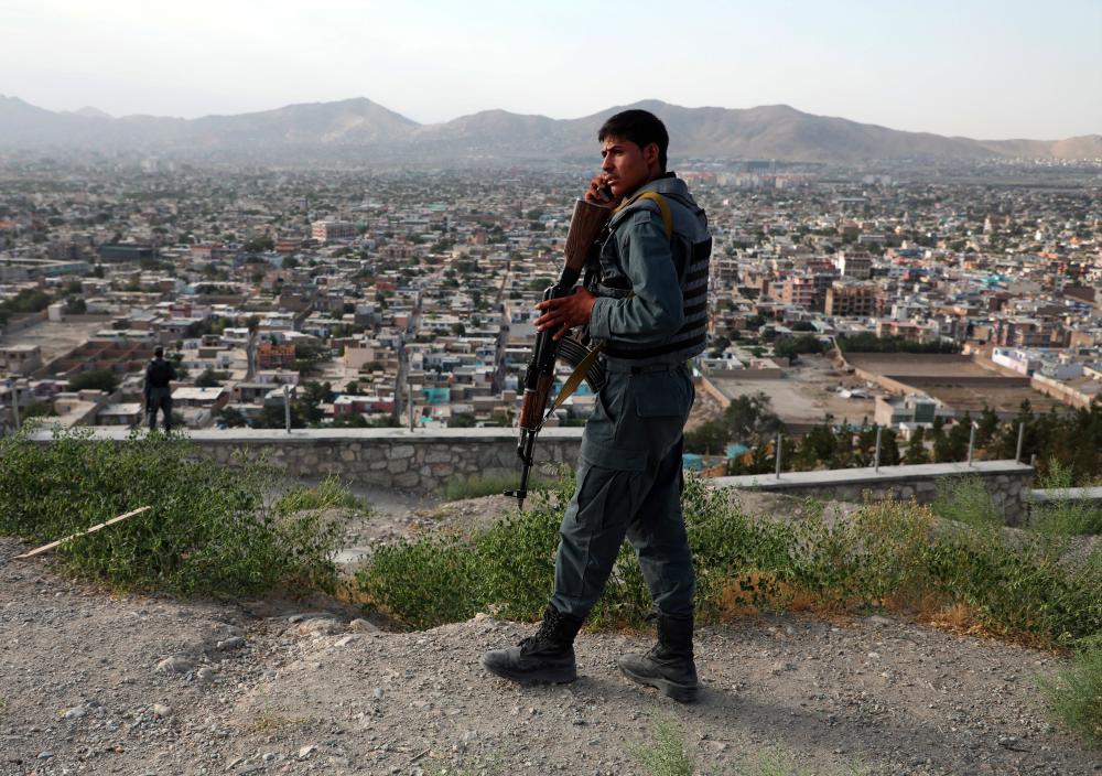An Afghan policeman keeps watch at a hilltop in Kabul, Afghanistan July 23, 2019. - Reuters