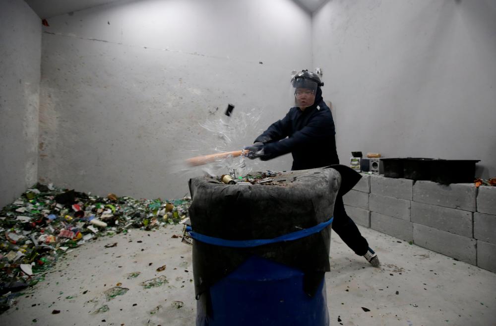 A customer wearing protective gear smashes a wine bottle in an anger room in Beijing, China January 12, 2019. Picture taken Jan 12, 2019. — Reuters