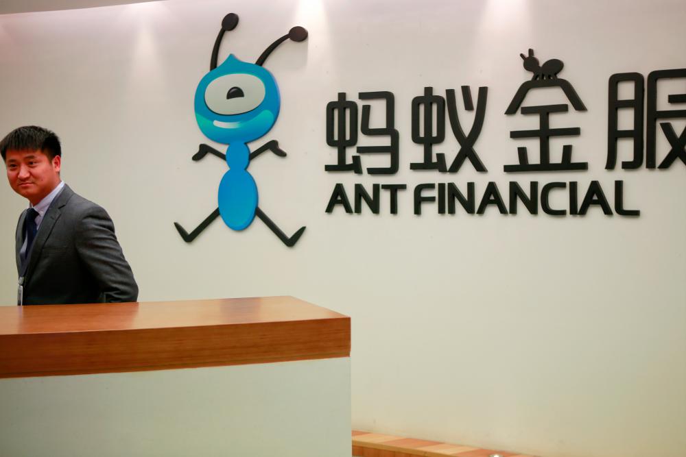 An employee stands next to the logo of Ant Financial Services Group, Alibaba's financial affiliate, at its headquarters in Hangzhou, Zhejiang province. – REUTERSPIX