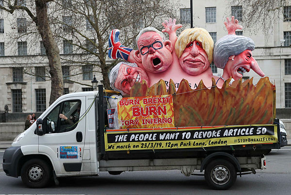 An anti-Brexit meddage on the back of a van is seen driving through Central London by the government buildings on Whitehall — AFP