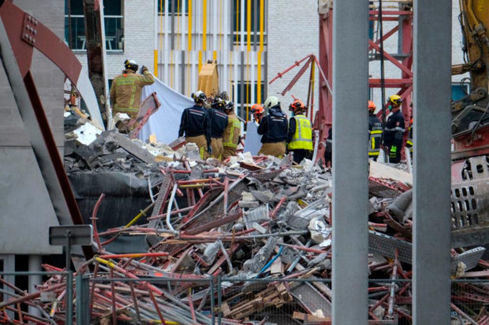 Rescue workers inspect the rubble of a collapsed building, a day after a school construction site partially collapsed in the Belgian city of Antwerp on June 19, 2021. — AFP