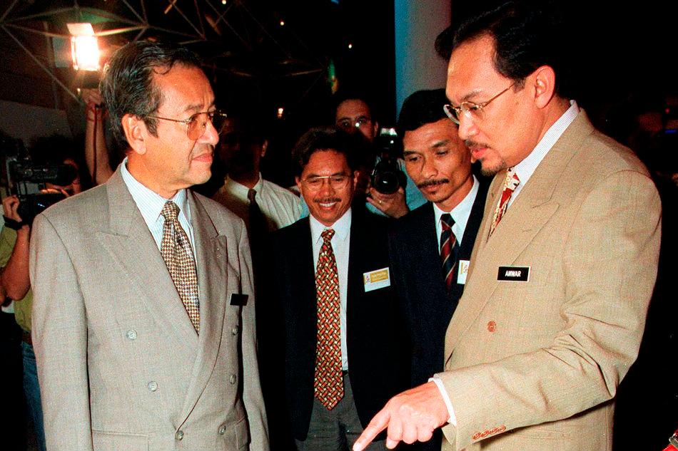 Tun Mahathir Mohamad (L) chats with Datuk Seri Anwar Ibrahim during a function in Kuala Lumpur, May 9, 1997. — Reuters