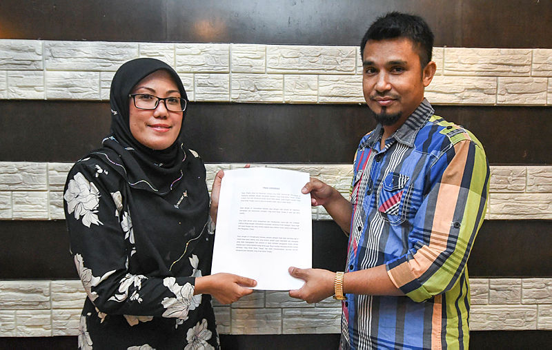 Majdah Muhamad (L) who is representing Tengku Amalin A’ishah Putri receive the letter of apology from Shaiful Afzan Mahamed, on Oct 21, 2019. — Bernama