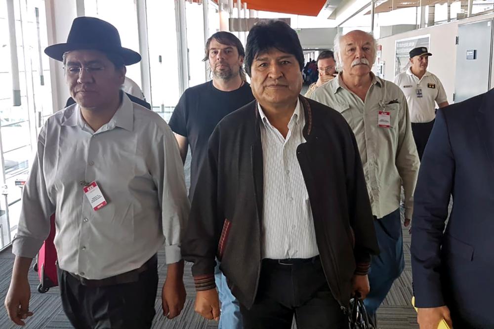 Handout photo released by the Argentina's Association of State Workers (ATE) and the Workers' Central Union of Argentina (CTA), of Bolivian ex-President Evo Morales (C) and Bolivian former Foreign Minister Diego Pary Rodriguez (L) walking upon their arrival at Ezeiza airport in Buenos Aires on Dec 12. — AFP