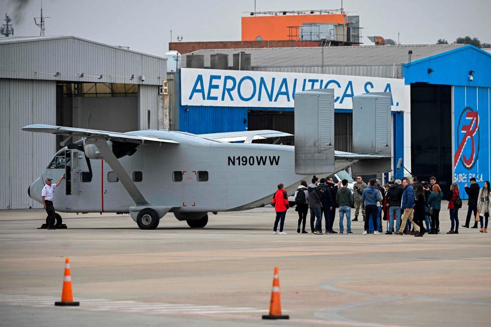 Members of human rights organizations, relatives and victims of the dictatorship, gather behind the Short SC-7 Skyvan aircraft used in the last Argentine military dictatorship (1976-1983) by the Naval Prefecture under registration PA-51, as it sits on the tarmac upon landing at Jorge Newbery International Airport in Buenos Aires, on June 24, 2023. AFPPIX