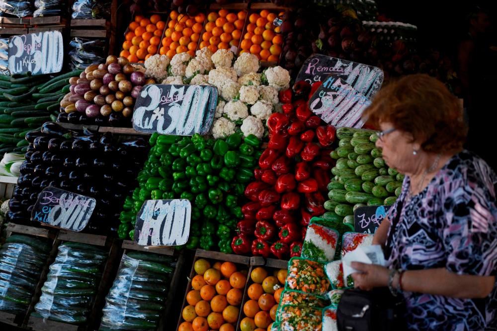 A woman checking prices at a vegetables stall in Buenos Aires. Sky-high consumer prices have sapped Argentinians’ purchasing power. – AFPpic