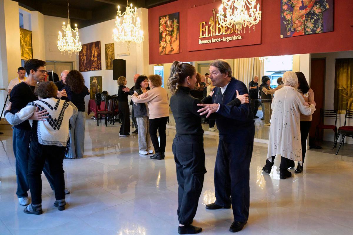 People suffering from Parkinson’s disease dance during a tango therapy session in Buenos Aires on August 26, 2025. Some 200 patients have attended the biannual tango workshops organized for the past 15 years by Buenos Aires’ Ramos Mejía public hospital, aimed at studying their impact on the progression of this incurable neurodegenerative disease and providing rehabilitation tools, neurologists in charge told AFP. (Photo by JUAN MABROMATA / AFP)