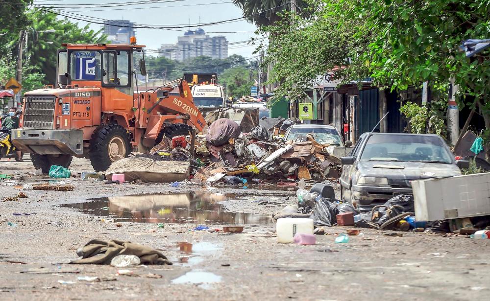 A bulldozer being used to clear debris off the streets in Padang Jawa, Shah Alam, which was one of the most severely flooded areas. Adib rawi yahya/THESUNpix