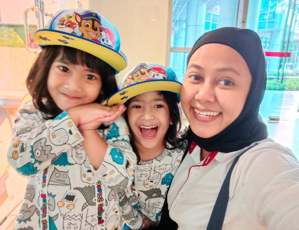 Ariza Husof with her twins Hayder Andrian Hadi Hasnul (left) and Hayden Allyyan at Sime Darby Plantation Childcare Centre.
