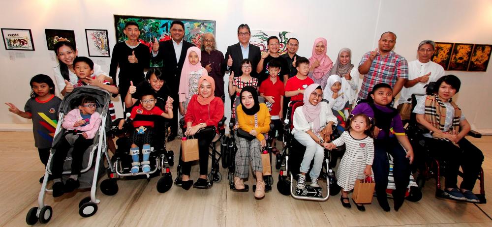 Wan Marzimin and Shahril Azuar with guests artists and children at the exhibition.