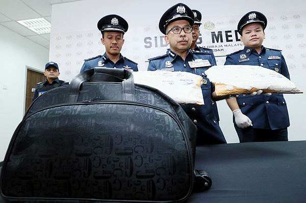 Kedah Customs director Datuk Johari Alifiah (C) and his officers display the methamphetamine drugs seized from a purported drug mule on the ICQS Complex walkway on Dec 16, 2018. — BBXpress