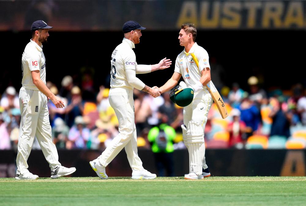 Australia's Marnus Labuschagne (R) shakes hands with Ben Stokes of England after Australia won the first Ashes cricket Test match against England on day four at the Gabba in Brisbane on December 11, 2021. AFPpix