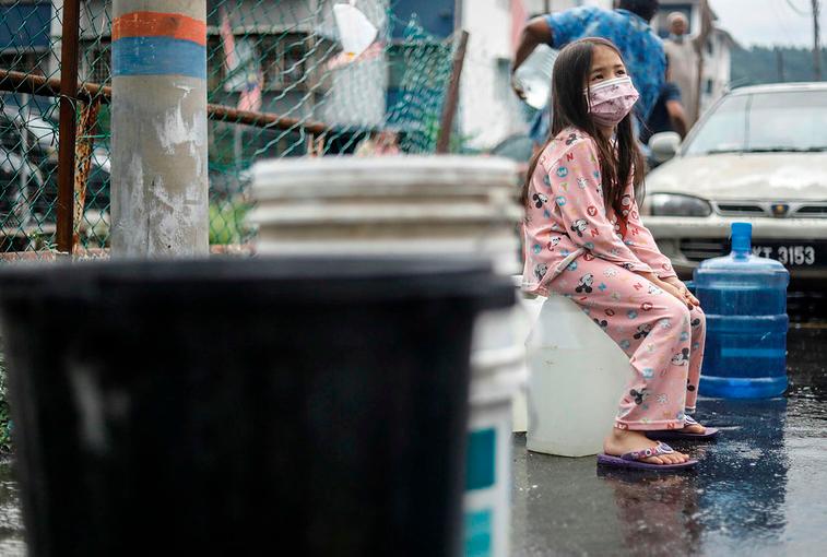 $!SUCH INCONVENIENCE ... Nur Natasha Balqis Abdul Qudus waiting for her turn to collect water from a relief tanker at a residential estate in Batu Caves, Selangor yesterday.– ASHRAF SHAMSUL/THESUN